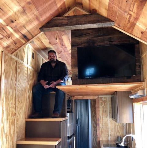 Man Sitting On Stairs in Tiny House Village Home
